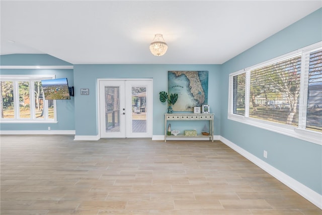 unfurnished room with french doors, light wood-style flooring, and baseboards