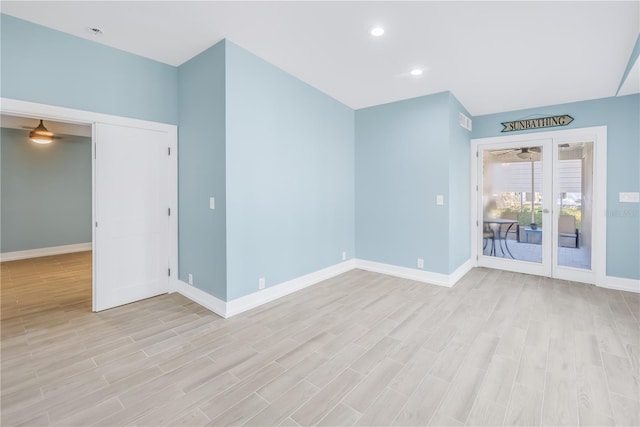 spare room featuring light wood-style floors, baseboards, and recessed lighting