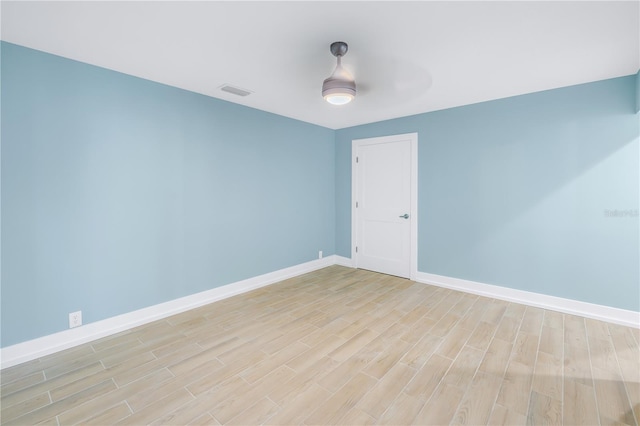 empty room featuring ceiling fan, light wood-style floors, and baseboards