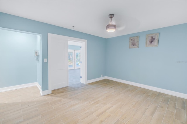 spare room featuring light wood-style flooring and baseboards