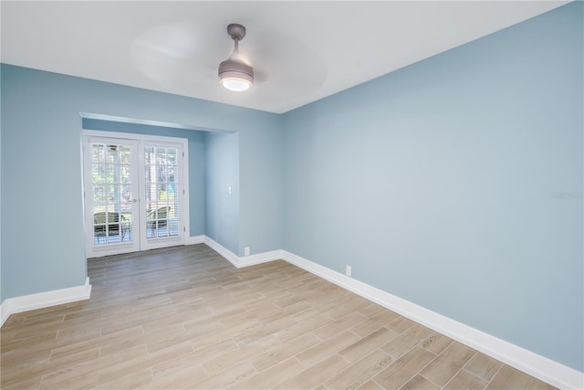 empty room with wood tiled floor, baseboards, and ceiling fan