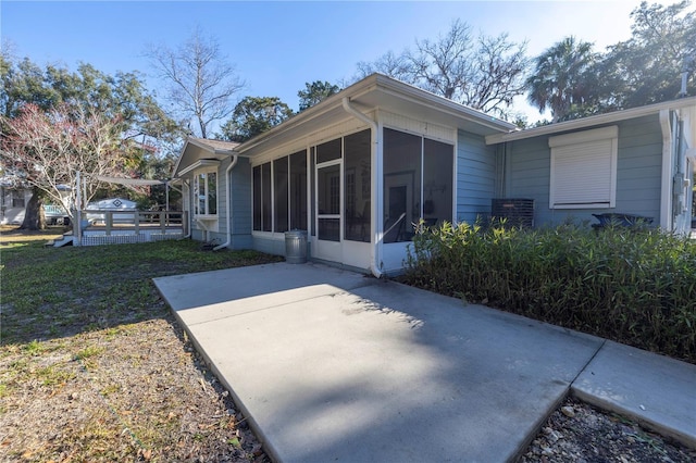 back of property featuring a sunroom and a lawn