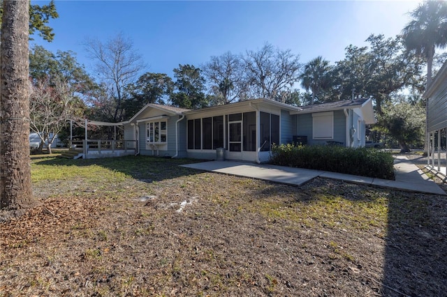 rear view of property with a sunroom and a yard