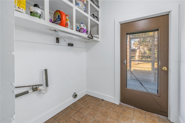 clothes washing area with tile patterned floors