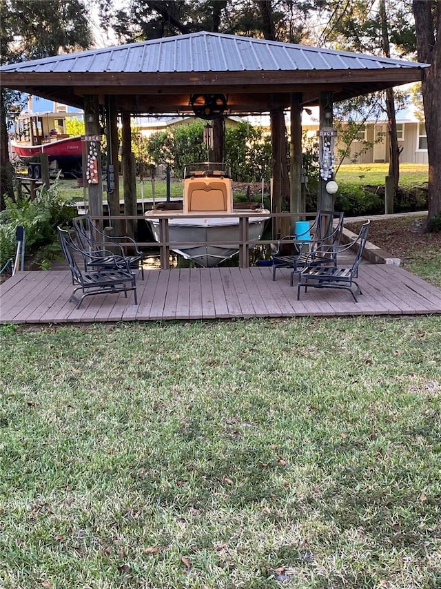 exterior space featuring a wooden deck, a lawn, and a gazebo