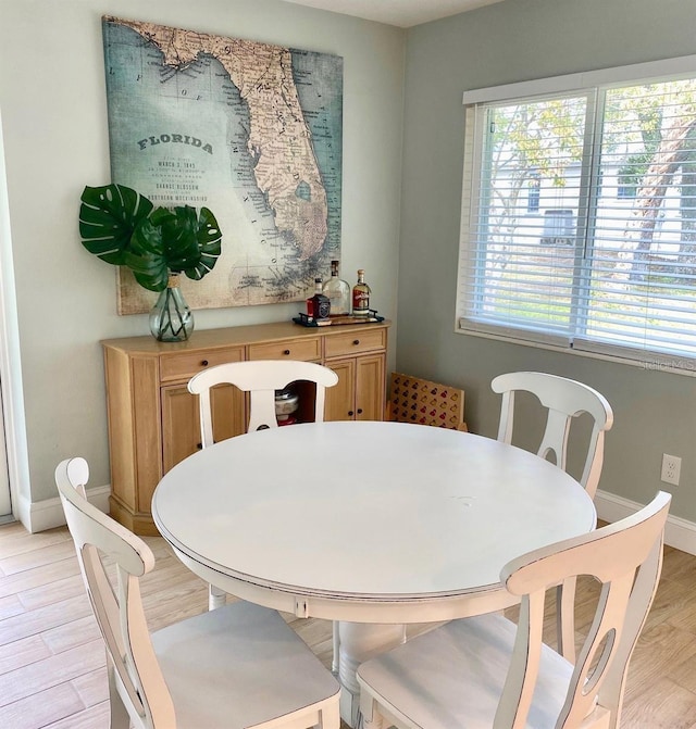 dining area featuring baseboards and light wood-style floors