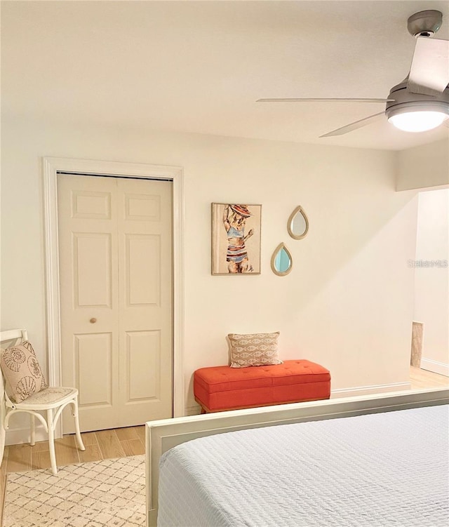 bedroom featuring a closet, light wood finished floors, and a ceiling fan