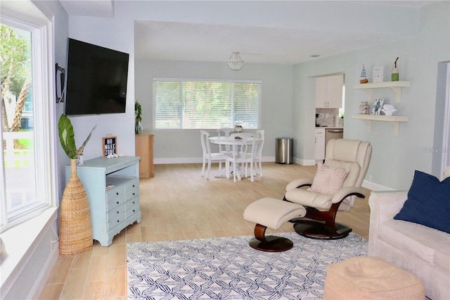 living area with light wood-style floors and baseboards