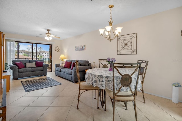 dining room featuring a chandelier, light tile patterned floors, a textured ceiling, and a ceiling fan