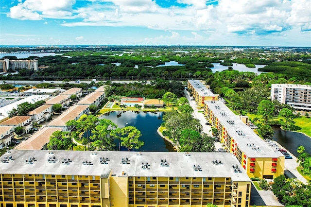 bird's eye view of apartment complex, a nearby body of water, and a tree filled landscape