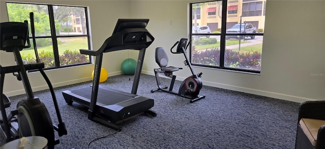 workout room with baseboards and carpet flooring