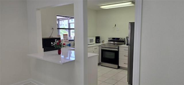 kitchen featuring stainless steel appliances, white cabinets, and light countertops