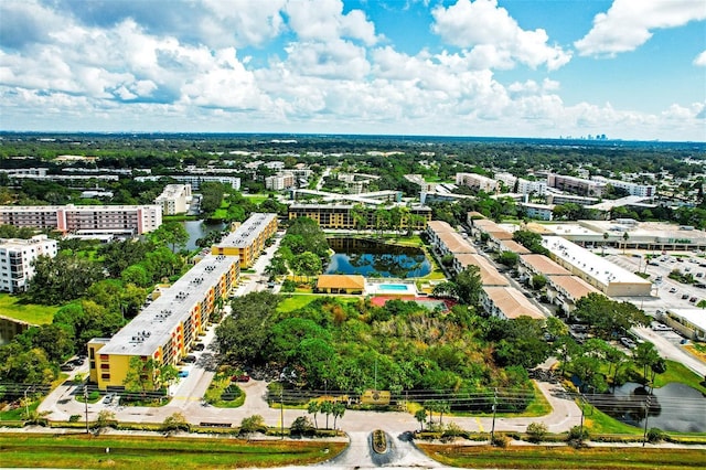 view of urban area featuring a nearby body of water and a tree filled landscape