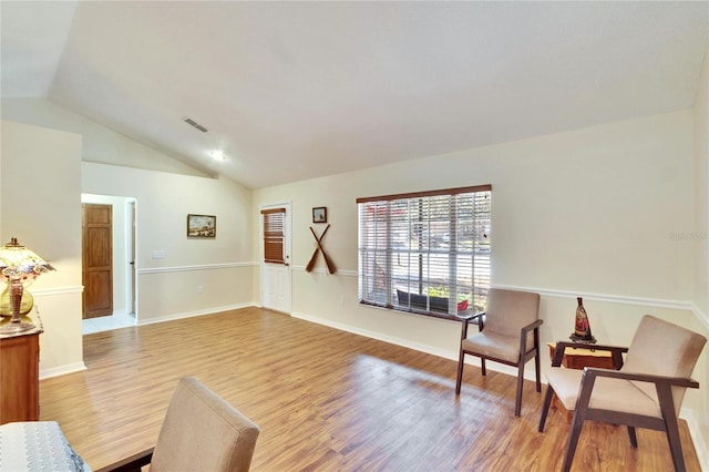 sitting room featuring lofted ceiling and light wood-type flooring