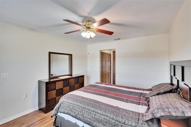 bedroom featuring ceiling fan, a textured ceiling, and light wood-type flooring