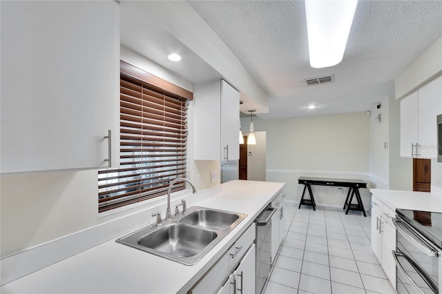 kitchen with sink, light tile patterned floors, hanging light fixtures, stainless steel appliances, and white cabinets