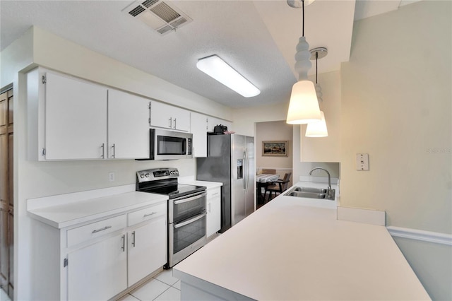 kitchen featuring pendant lighting, white cabinetry, appliances with stainless steel finishes, and sink