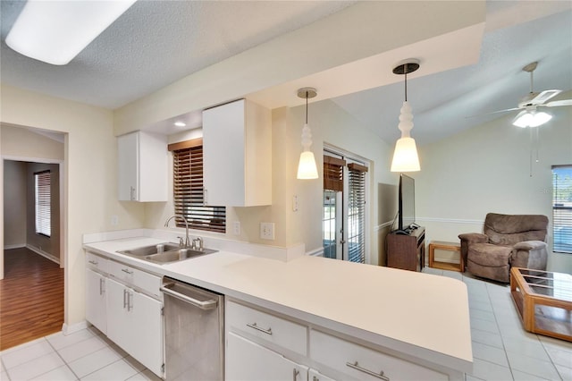 kitchen with pendant lighting, sink, stainless steel dishwasher, and white cabinets