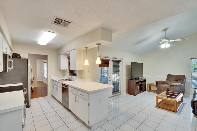 kitchen featuring sink, light tile patterned floors, stainless steel appliances, white cabinets, and decorative light fixtures