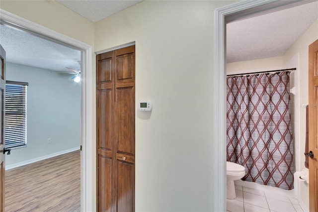 bathroom featuring toilet, tile patterned flooring, and a textured ceiling