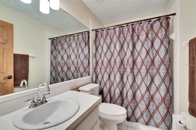 bathroom with tile patterned flooring, vanity, a textured ceiling, and toilet