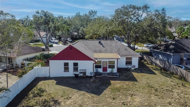 back of property with a lawn