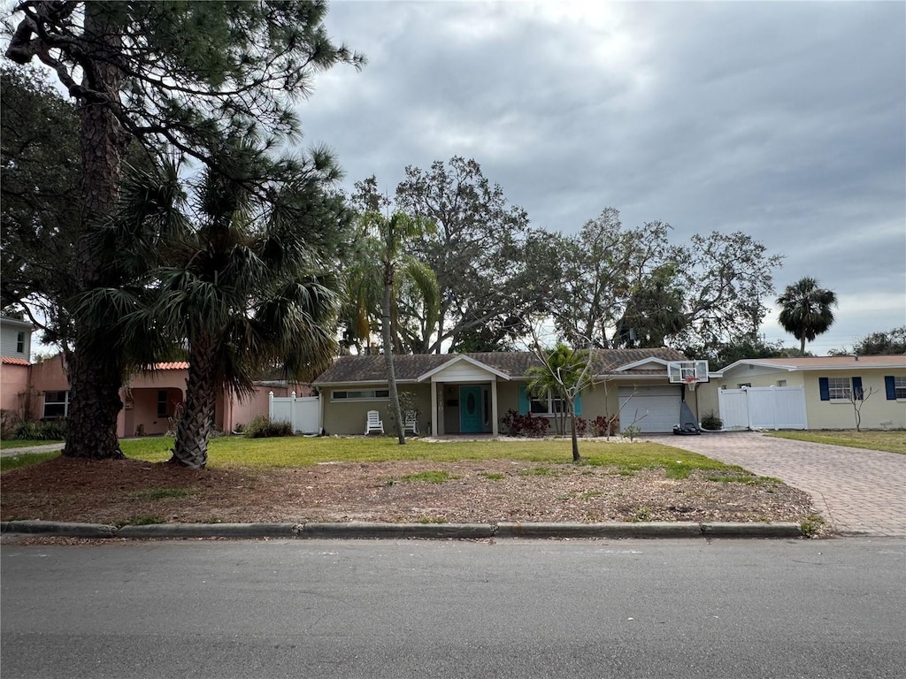 single story home featuring a garage and a front lawn