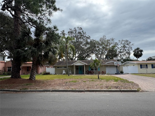 single story home featuring a garage and a front lawn