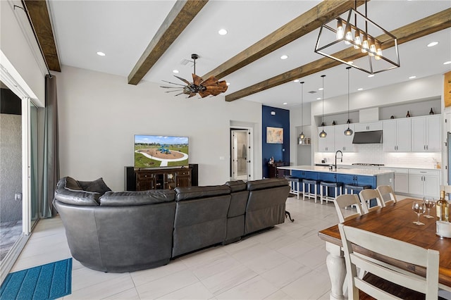 living room featuring sink, a notable chandelier, and beamed ceiling