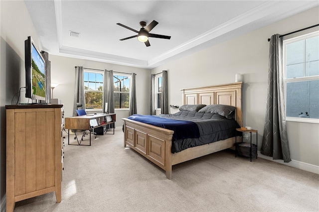 bedroom featuring a raised ceiling, light colored carpet, and ceiling fan