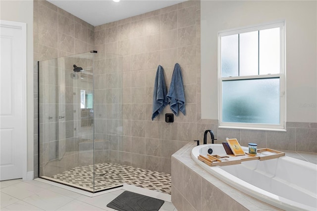 bathroom featuring plenty of natural light and independent shower and bath