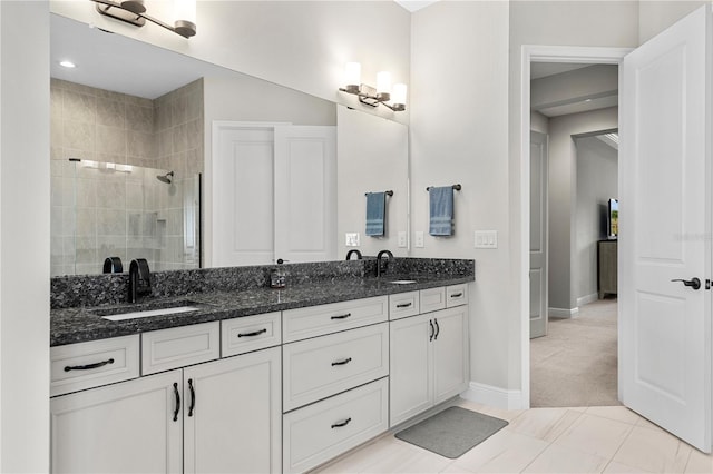 bathroom with vanity, tile patterned flooring, and tiled shower