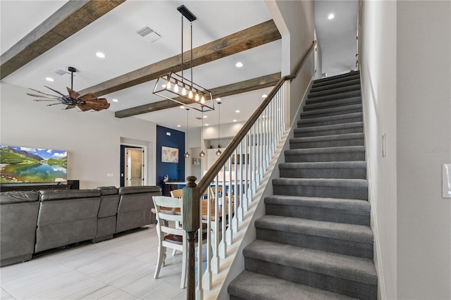 stairs featuring ceiling fan and beamed ceiling