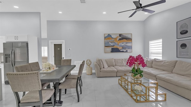 living room with a high ceiling, light tile patterned floors, and ceiling fan