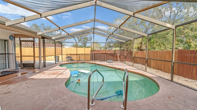 view of swimming pool featuring a lanai and a patio area