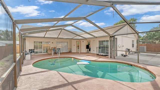 view of swimming pool featuring cooling unit, a lanai, and a patio