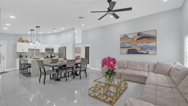 living room with a high ceiling and ceiling fan