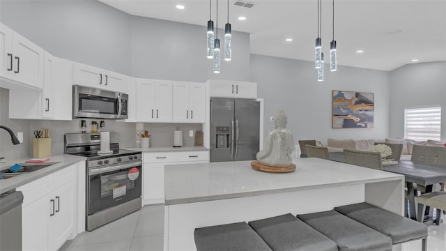 kitchen with pendant lighting, sink, stainless steel appliances, and white cabinets