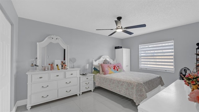 bedroom with ceiling fan, a textured ceiling, and light tile patterned flooring