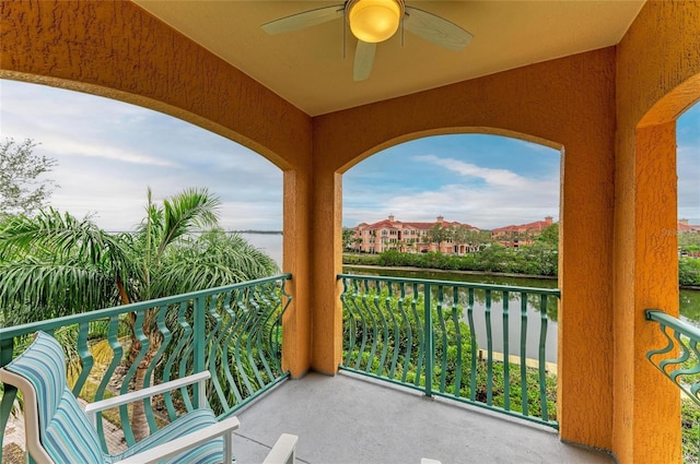 balcony featuring a water view and ceiling fan