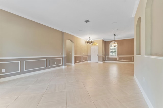 spare room featuring ornamental molding, a chandelier, and light tile patterned floors