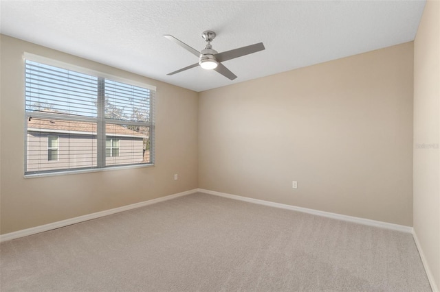 carpeted empty room with ceiling fan and a textured ceiling