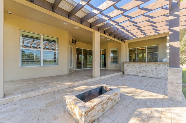 view of patio / terrace with an outdoor fire pit and a pergola