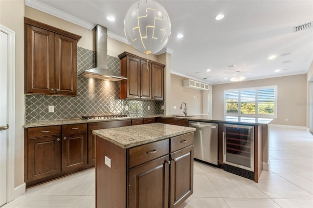 kitchen featuring beverage cooler, a center island, kitchen peninsula, stainless steel appliances, and wall chimney exhaust hood