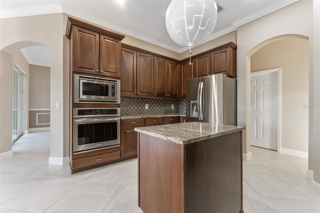 kitchen with dark brown cabinetry, light stone countertops, a center island, and appliances with stainless steel finishes