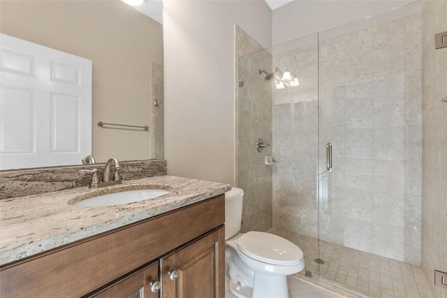 bathroom with walk in shower, vanity, and toilet