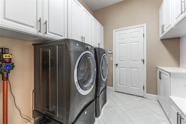 laundry area featuring cabinets and washing machine and clothes dryer