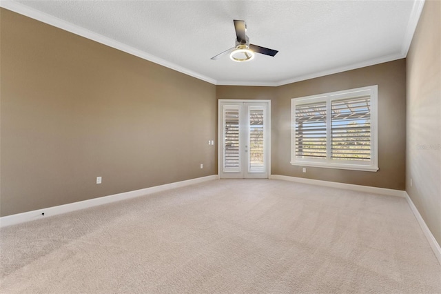 empty room with ceiling fan, ornamental molding, a textured ceiling, light carpet, and french doors