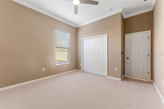 unfurnished bedroom featuring light colored carpet, ornamental molding, a closet, and ceiling fan