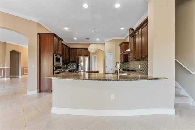 kitchen with pendant lighting, dark stone countertops, kitchen peninsula, stainless steel appliances, and crown molding